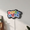 Unlit Numberblocks LED lightbox mounted on a wall in daylight