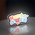 Numberblocks LED lightbox standing on a desk from an angled side view with white glow
