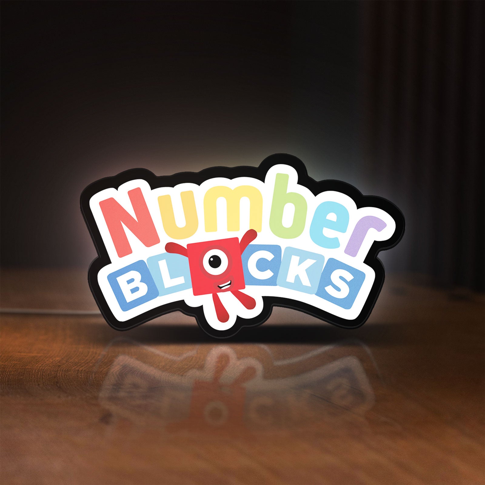 Front view of Numberblocks LED lightbox sign glowing on a wooden desk
