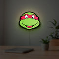Teenage Mutant Ninja Turtles LED lightbox hanging on a room wall with soft green light
