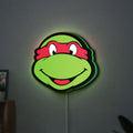 Teenage Mutant Ninja Turtles LED lightbox hanging on a wall with green glow
