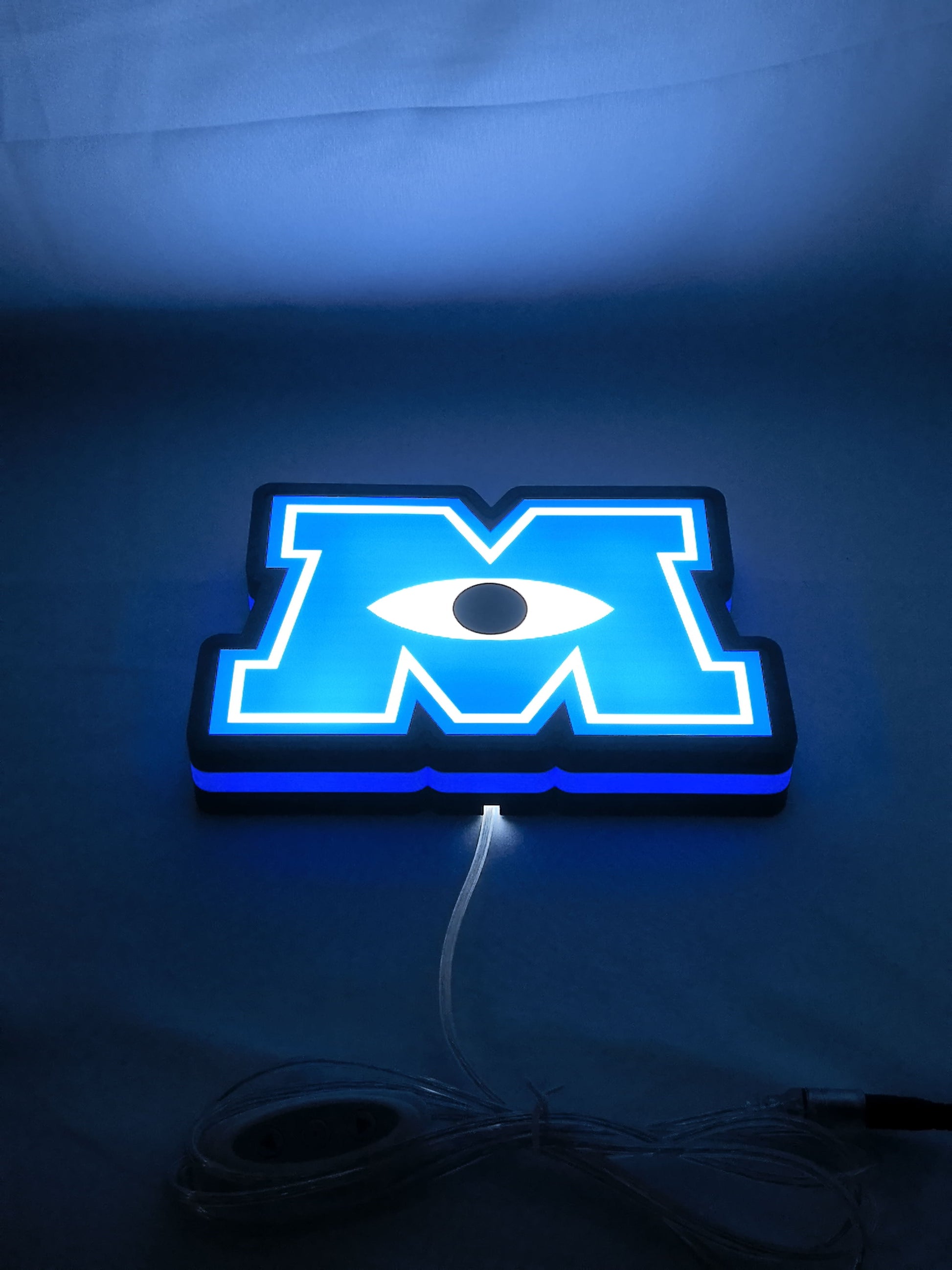 Illuminated flat lay angled view of Monsters University Illuminated Sign in 20cm, unique wall art for desk and room decor