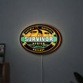 Survivor Africa LED lightbox hanging on a wall with orange glow