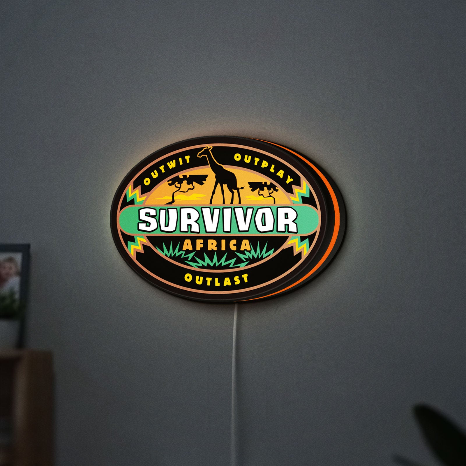 Survivor Africa LED lightbox hanging on a wall with orange glow