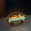 Survivor Africa LED lightbox standing on a desk from an angled side view with orange glow