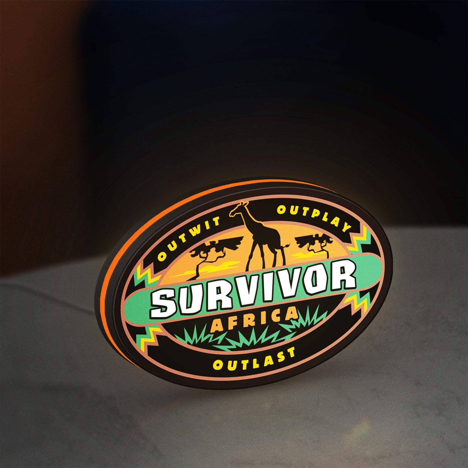 Survivor Africa LED lightbox standing on a desk from an angled side view with orange glow