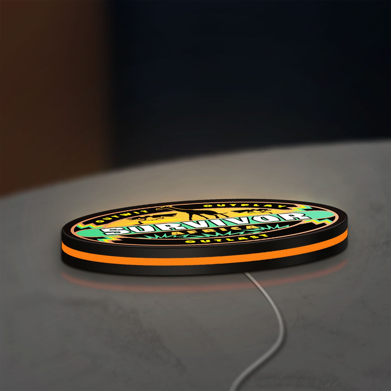 Survivor Africa LED lightbox lying flat on a desk with orange glow