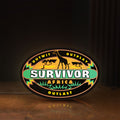 Front view of Survivor Africa LED lightbox sign glowing on a wooden desk