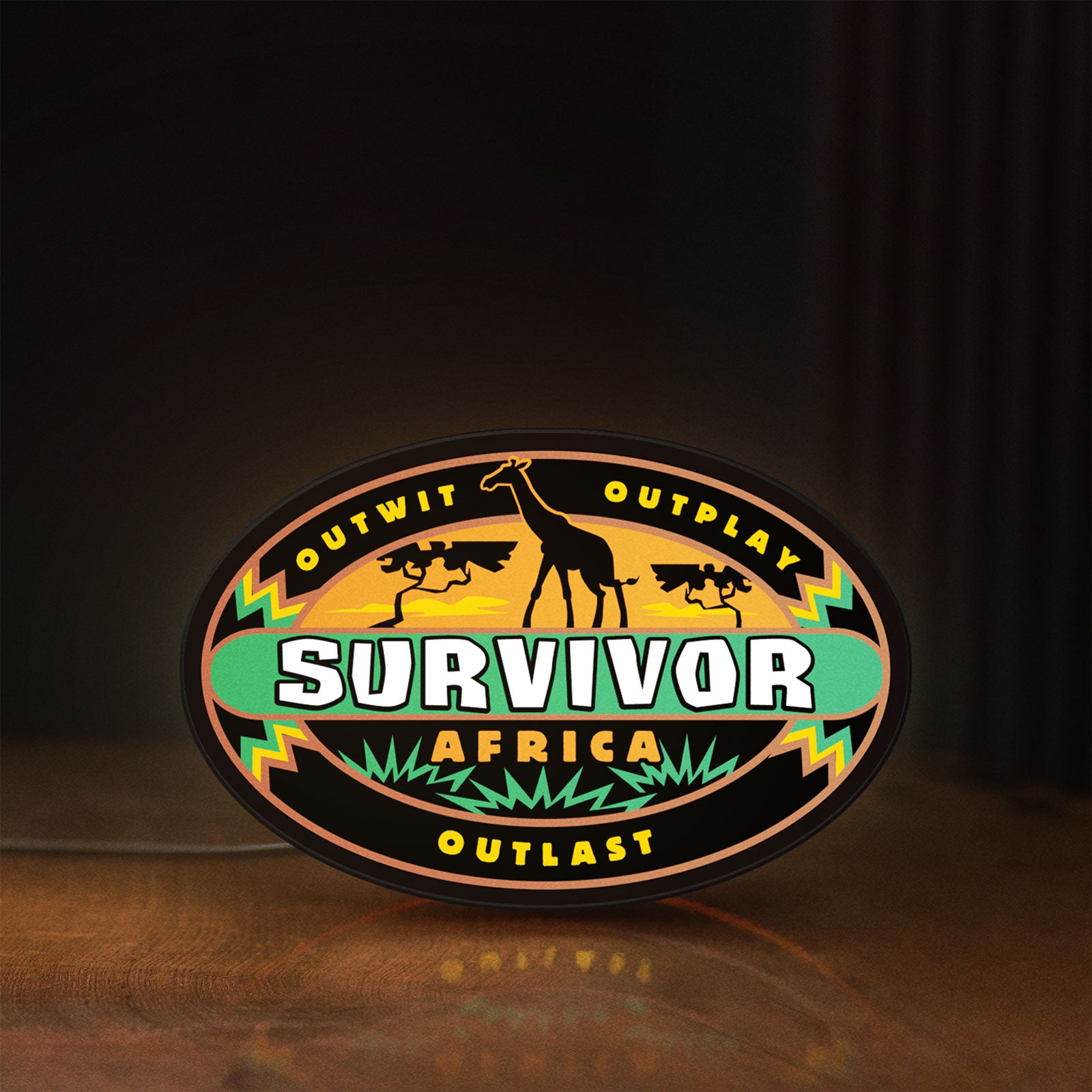 Front view of Survivor Africa LED lightbox sign glowing on a wooden desk