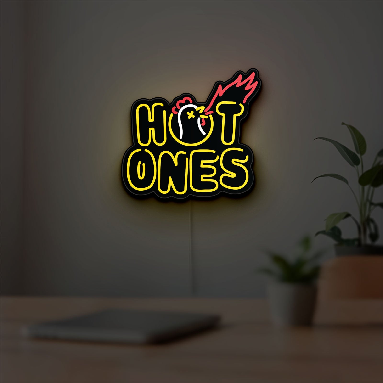 Hot Ones LED lightbox hanging on a room wall with soft yellow light