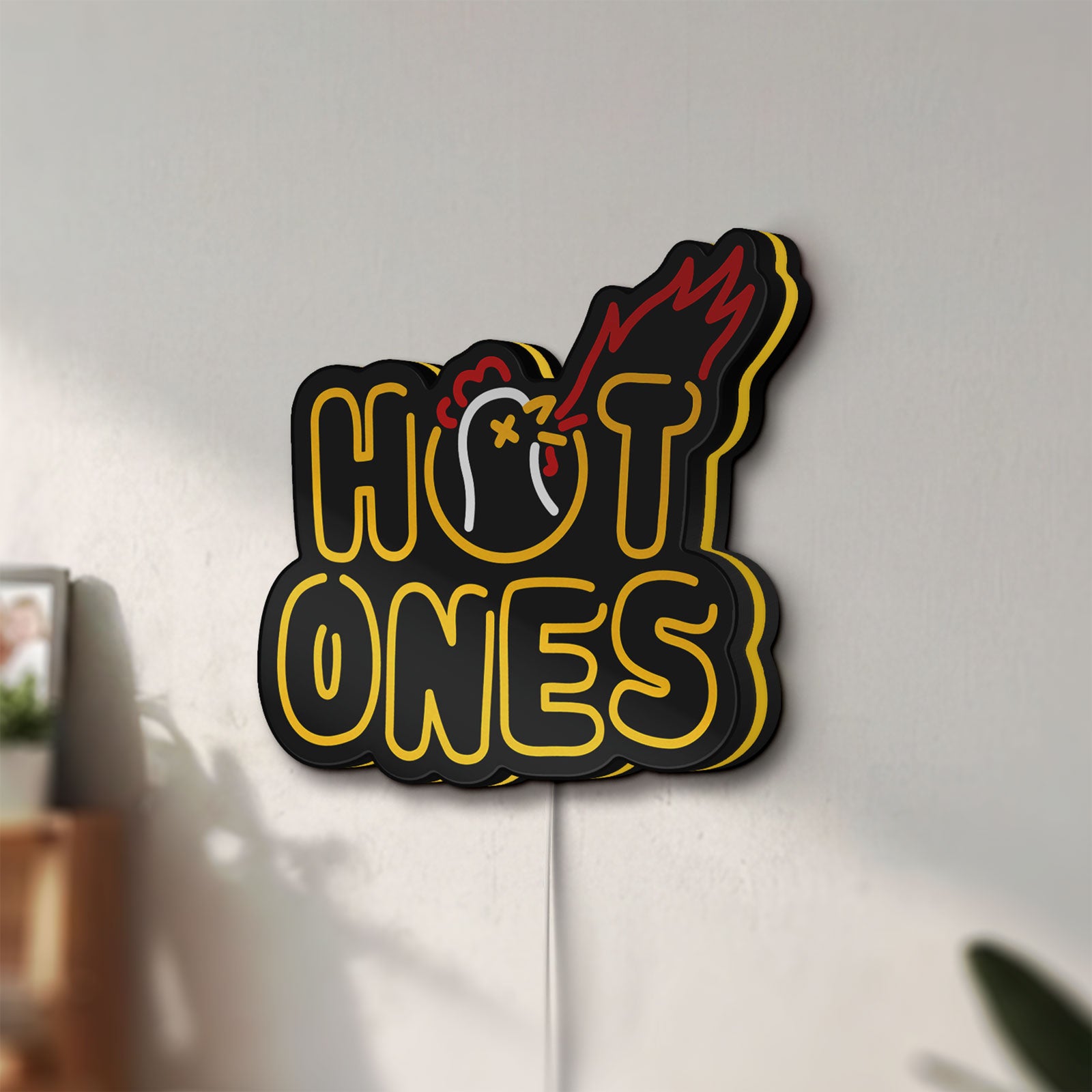 Unlit Hot Ones LED lightbox mounted on a wall in daylight