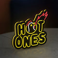 Hot Ones LED lightbox standing on a desk from an angled side view with yellow glow