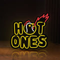 Front view of Hot Ones LED lightbox sign glowing on a wooden desk