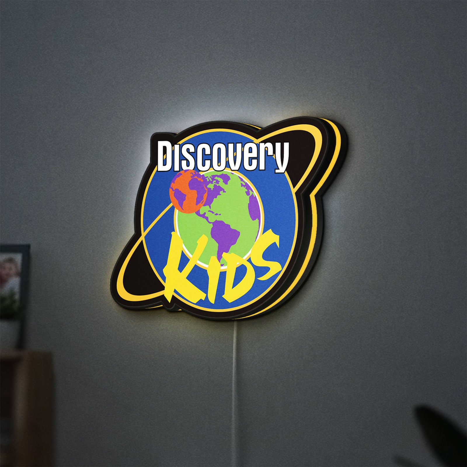 Discovery Kids Space LED lightbox hanging on a wall with yellow glow
