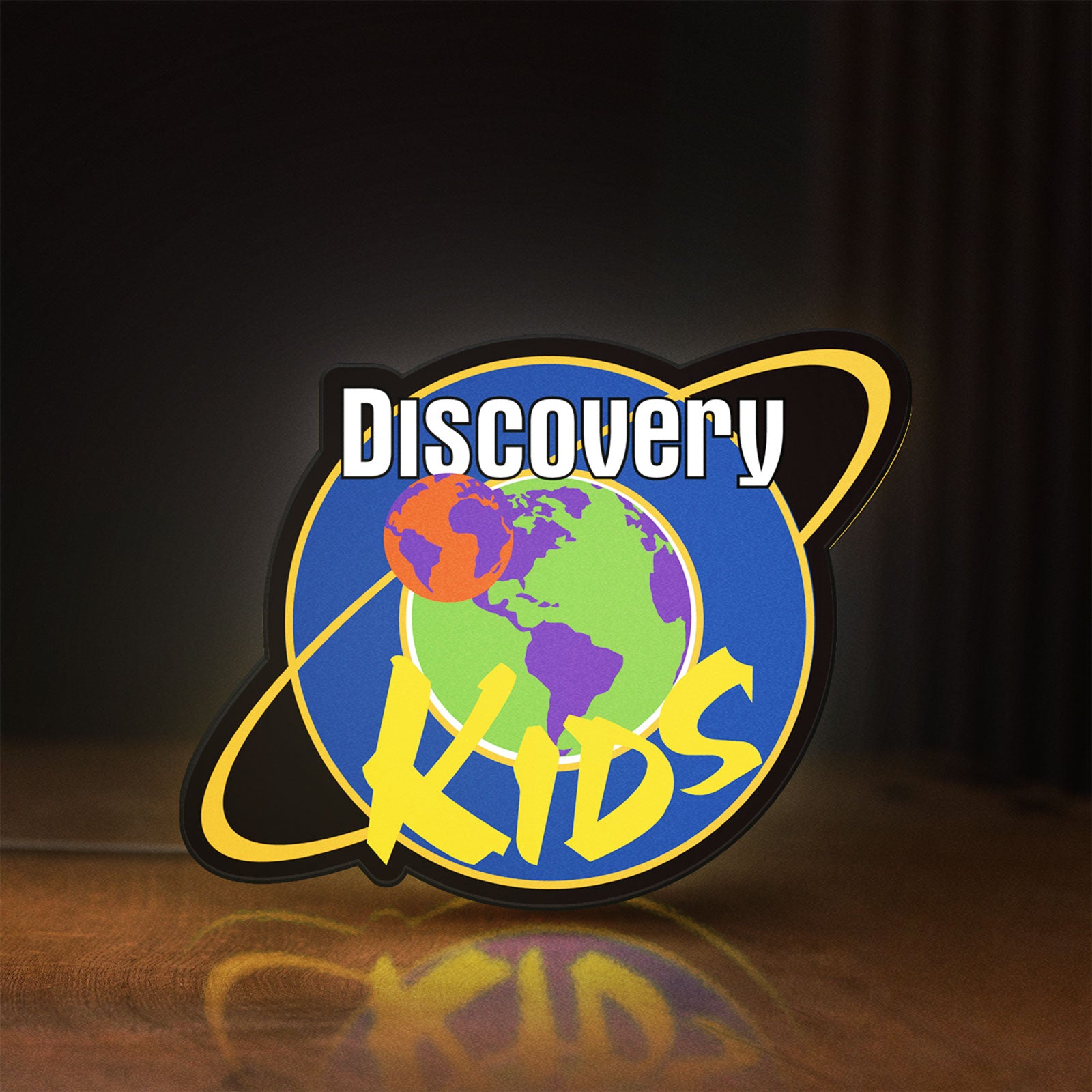 Front view of Discovery Kids Space LED lightbox sign glowing on a wooden desk
