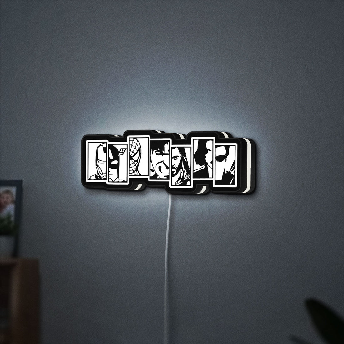 Avengers LED lightbox hanging on a wall with white glow