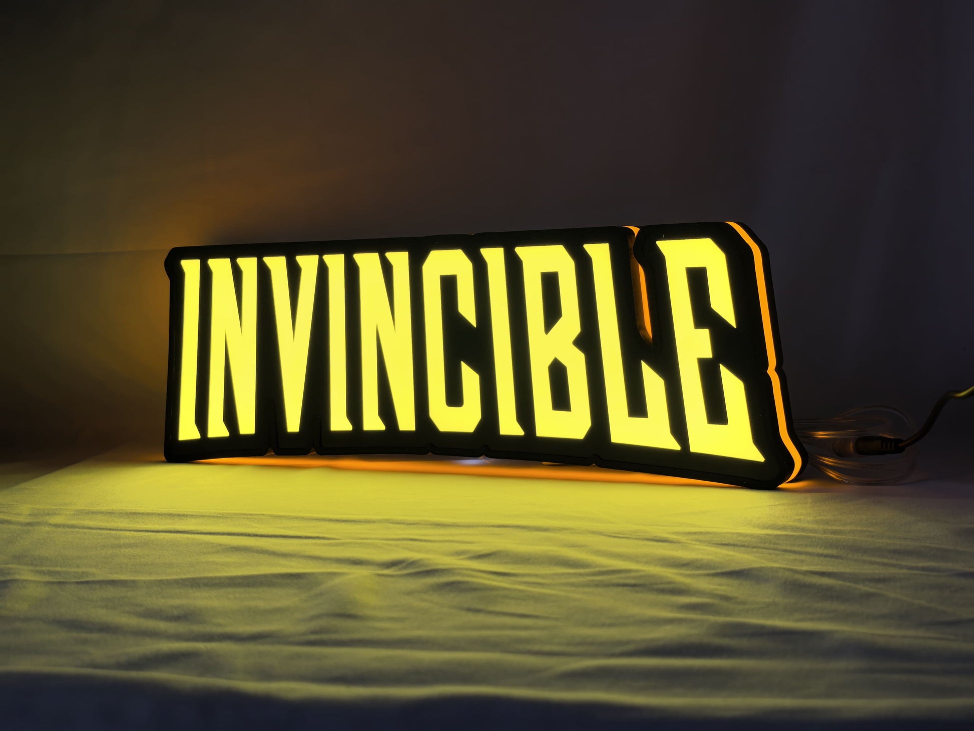 Invincible LED Sign (40cm) - Illuminated angled view standing, cool game room and bedroom decor