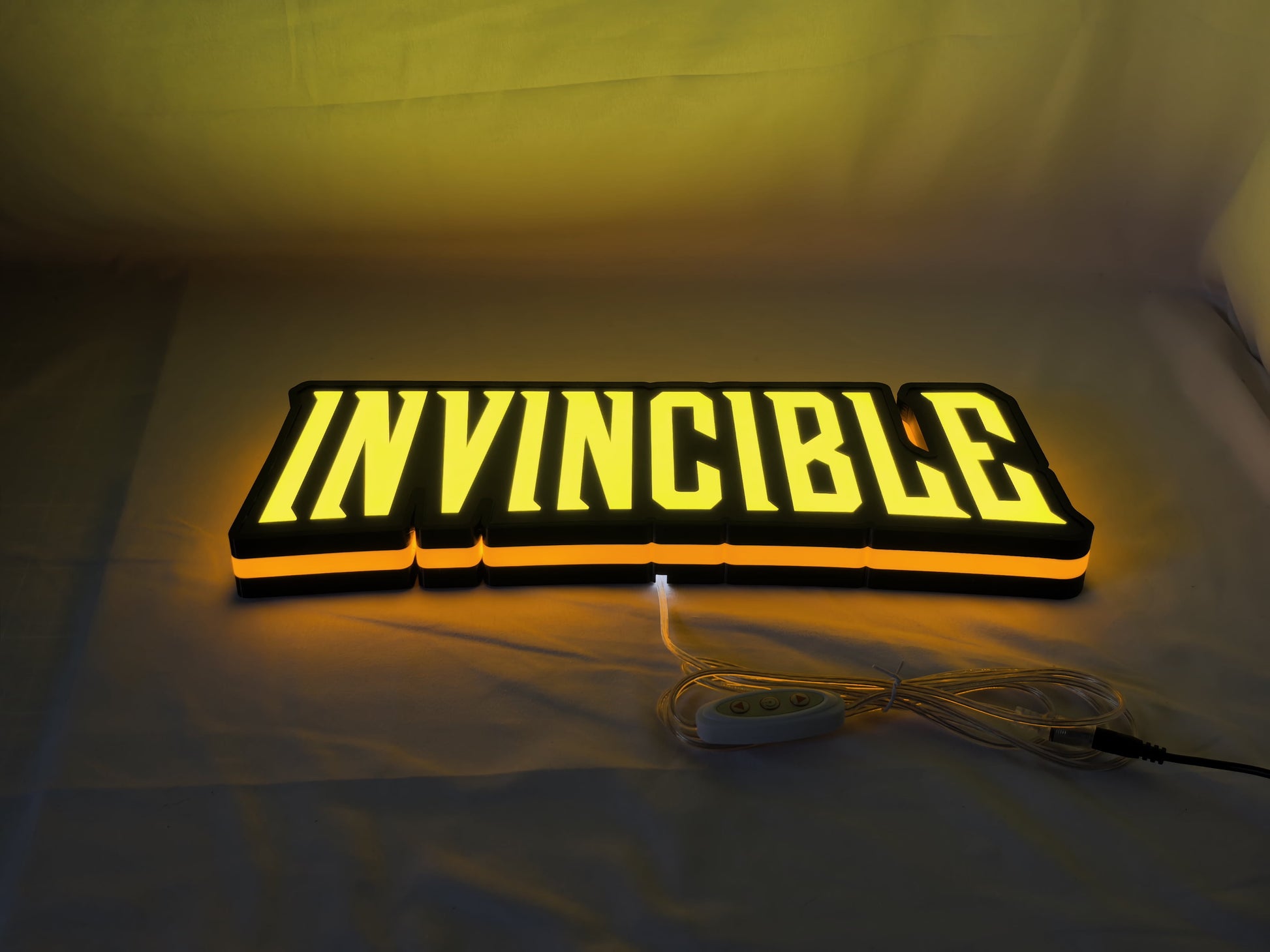 Invincible LED Sign (40cm) - Illuminated flat lay angled view, cool game room and bedroom decor