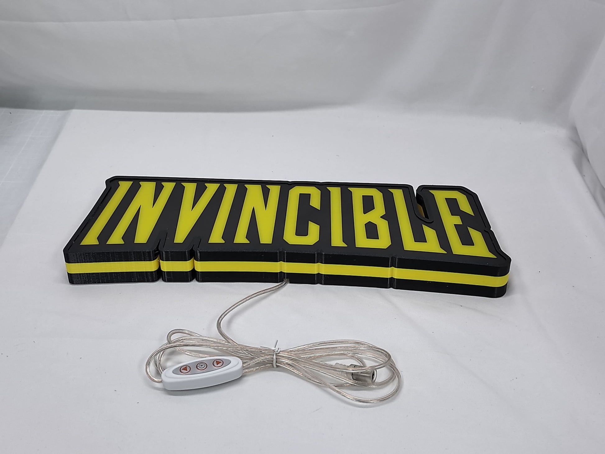 Invincible LED Sign (40cm) - Unlit flat lay angled details, cool game room and bedroom decor