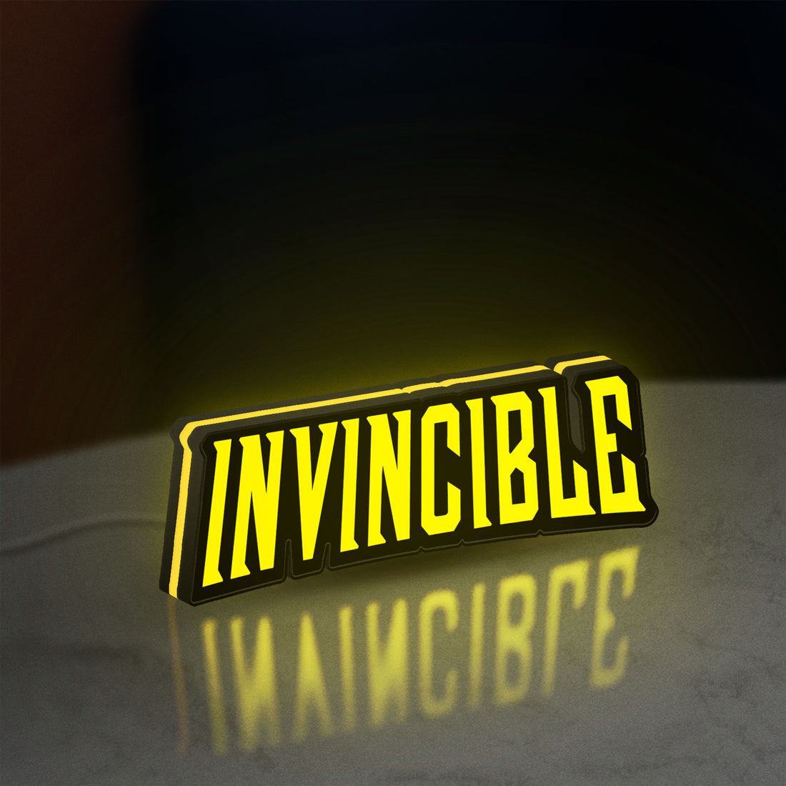 Invincible LED lightbox hanging on a wall with yellow glow