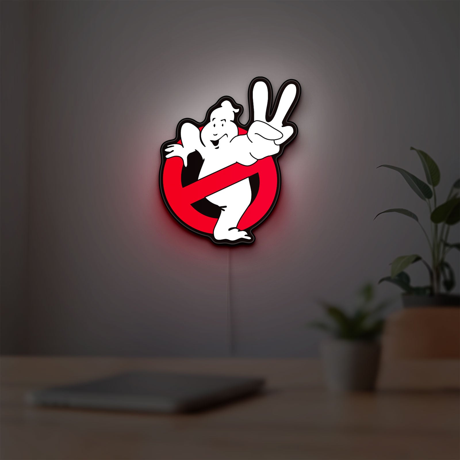 Ghostbusters LED lightbox hanging on a room wall with soft red light