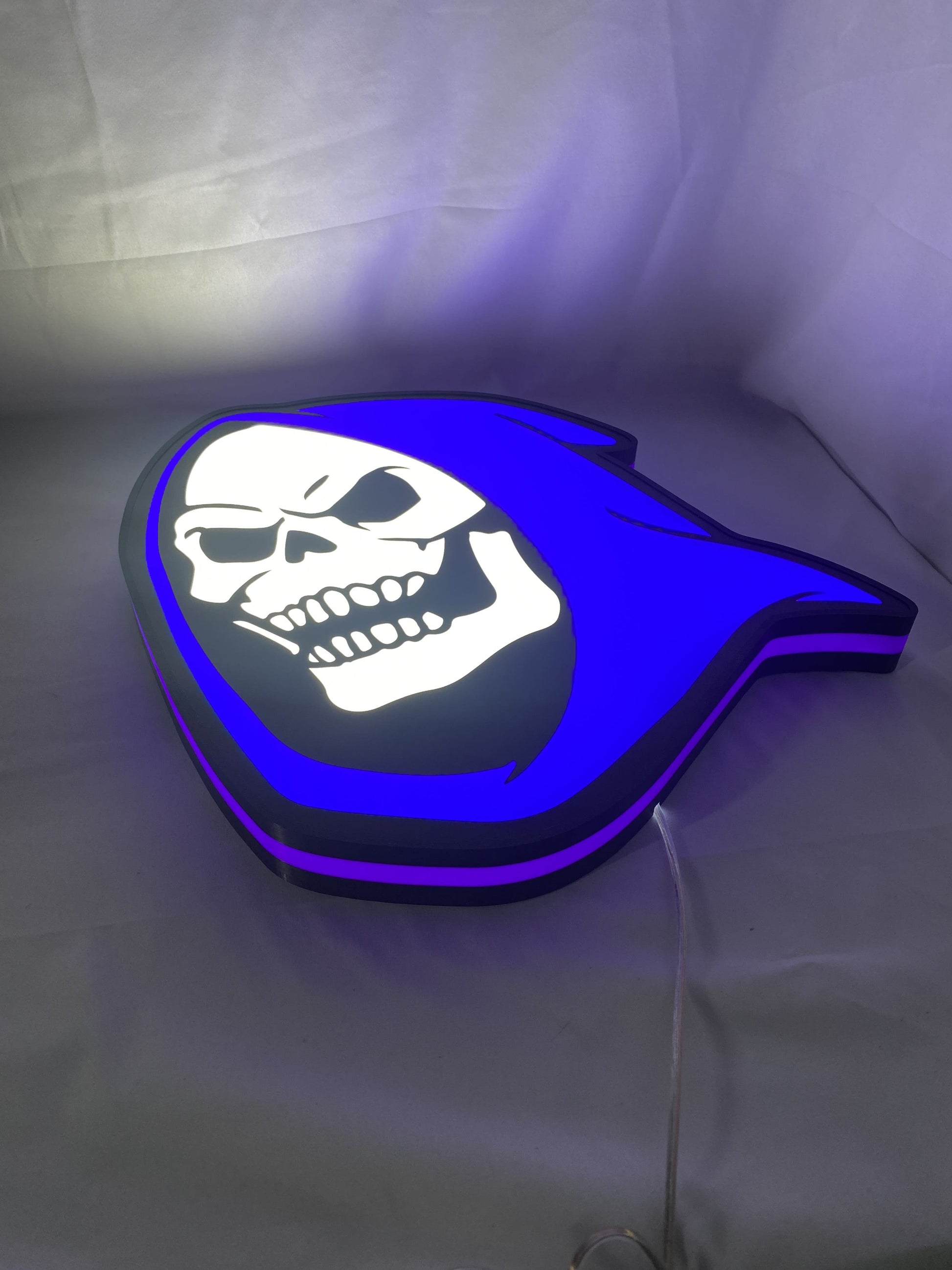 Illuminated flat lay angled view of Skeletor Illuminated Sign in 40cm, unique wall art for desk and room decor