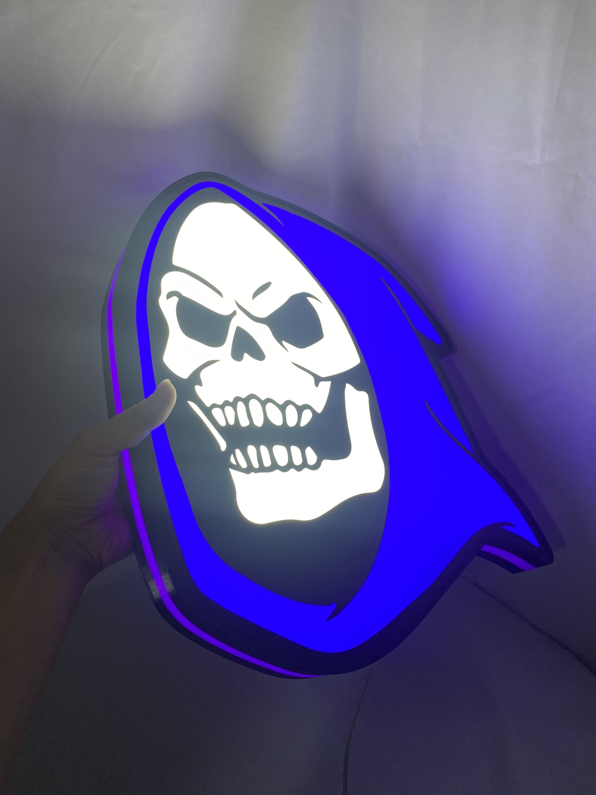Illuminated handheld size reference of Skeletor 3D LED Sign in 40cm, unique wall art for desk and room decor