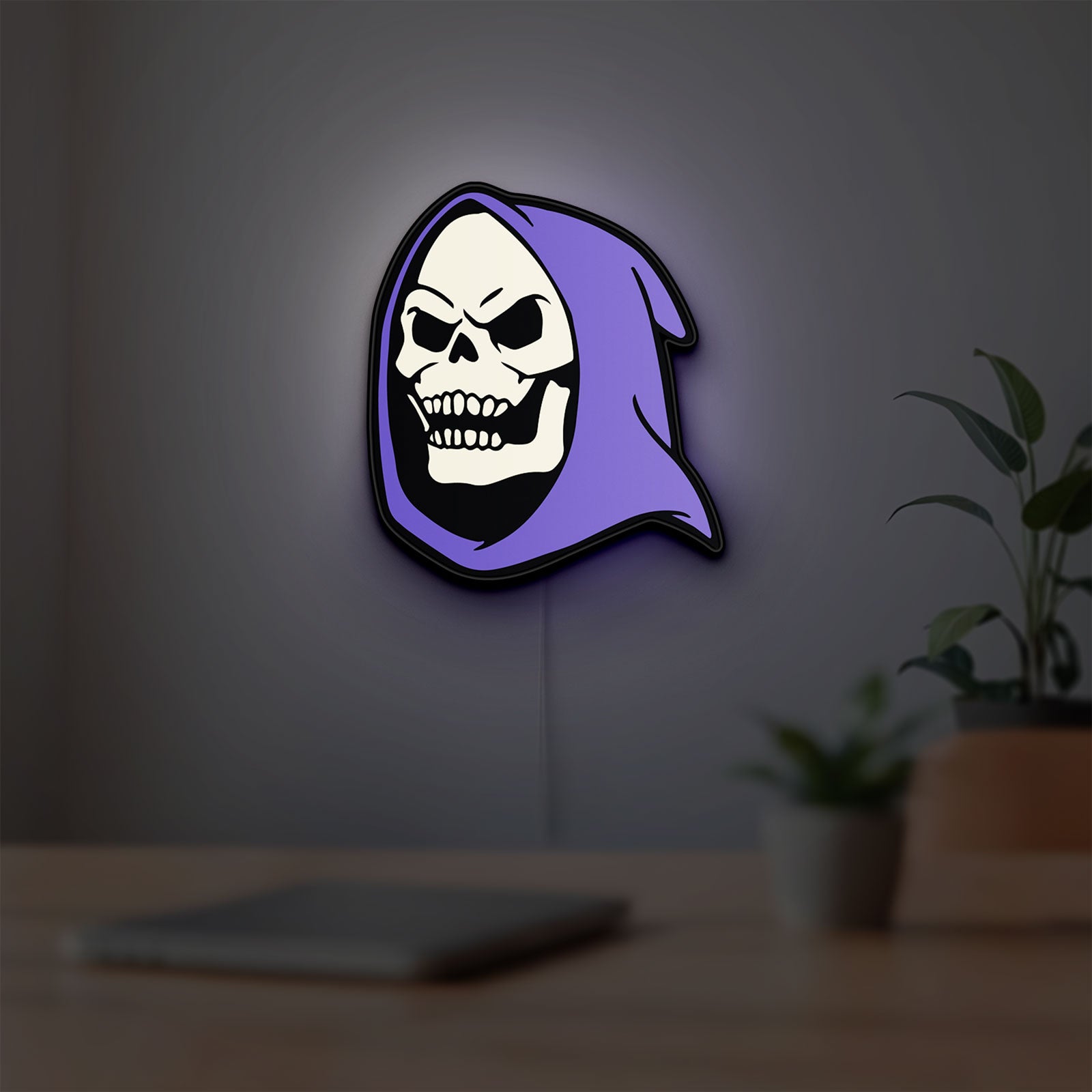 Skeletor LED lightbox hanging on a room wall with soft purple light