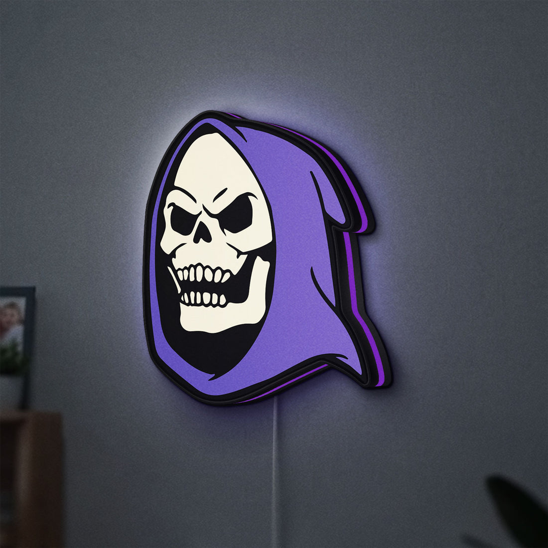 Skeletor LED lightbox hanging on a wall with purple glow