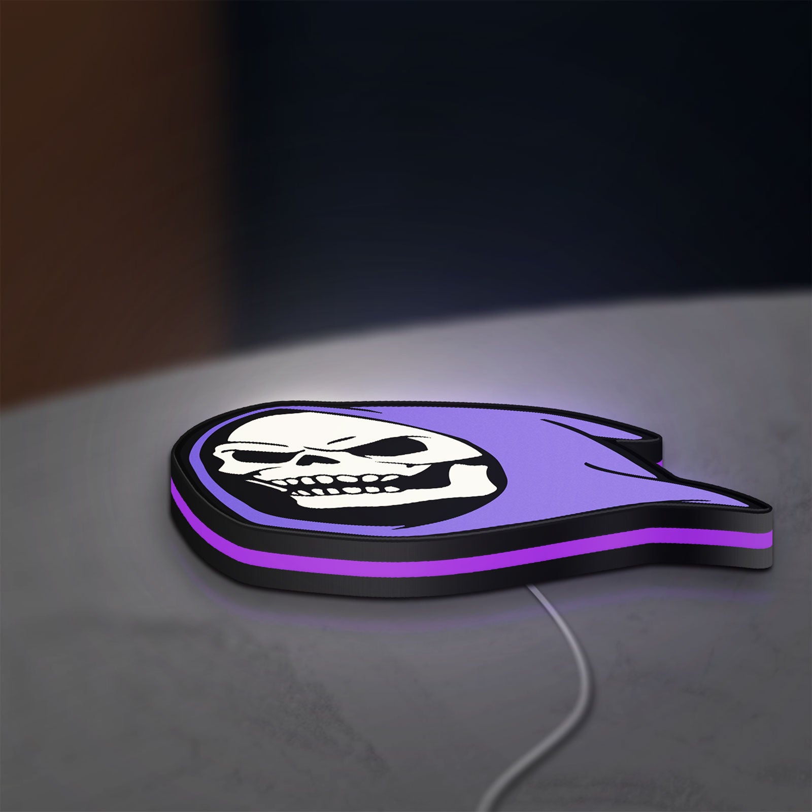 Skeletor LED lightbox lying flat on a desk with purple glow