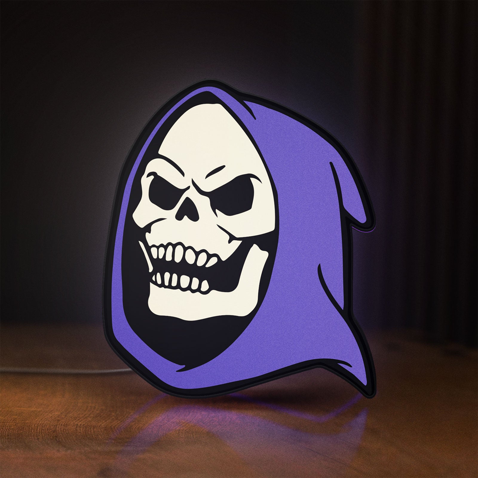 Front view of Skeletor LED lightbox sign glowing on a wooden desk