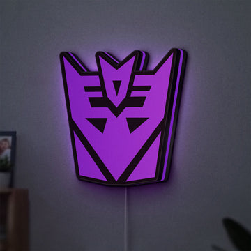 Decepticon LED lightbox hanging on a wall with purple glow