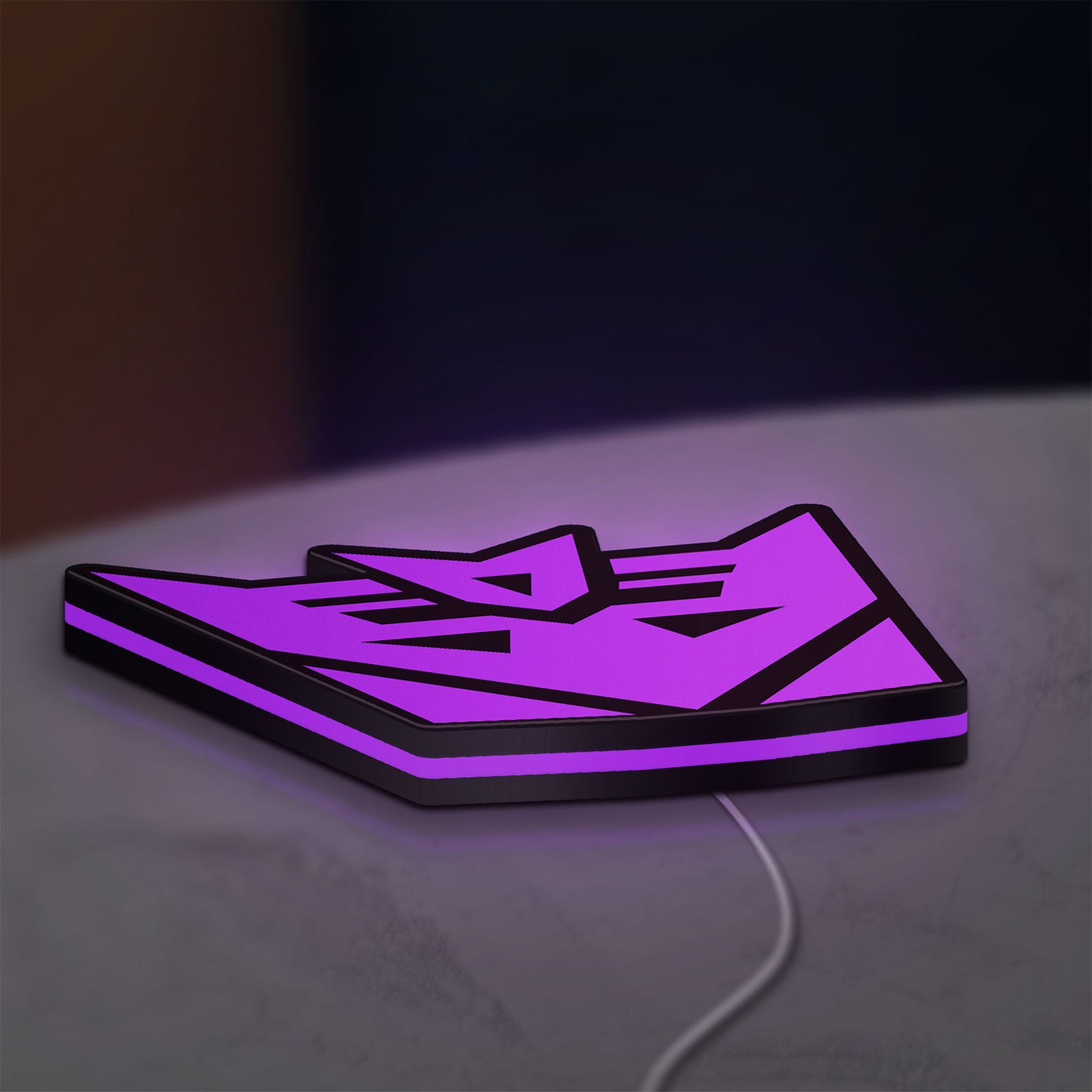 Decepticon LED lightbox lying flat on a desk with purple glow