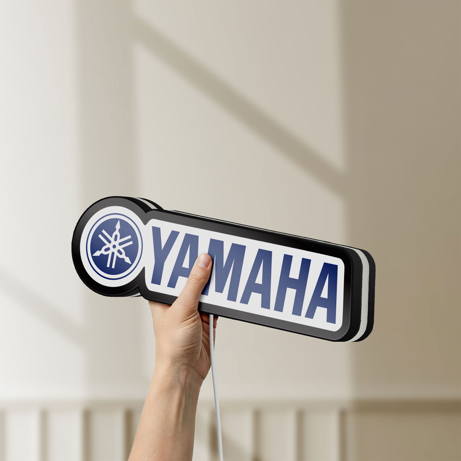 Unlit Yamaha LED lightbox held by hand to show size and details