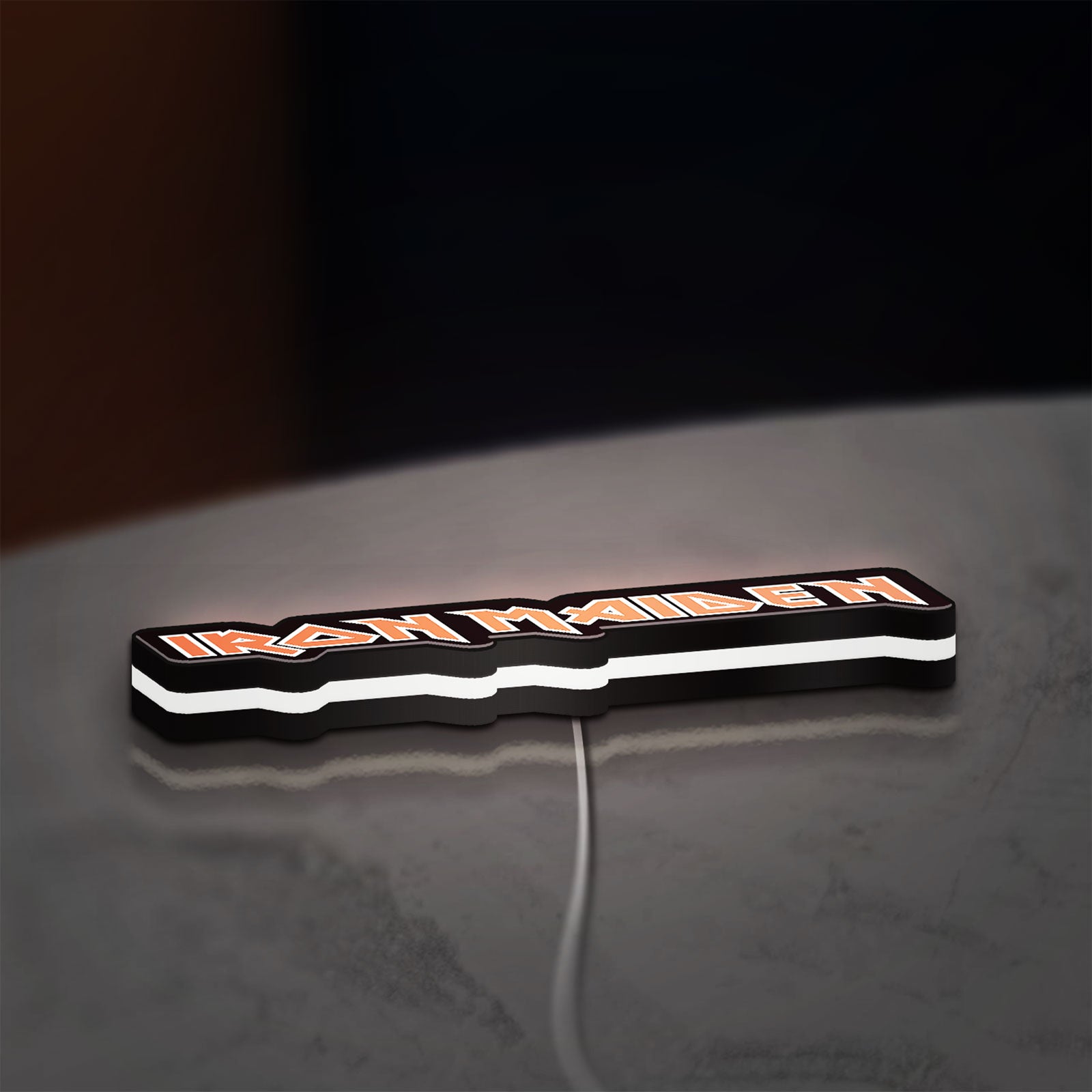 Iron Maiden LED lightbox lying flat on a desk with white glow