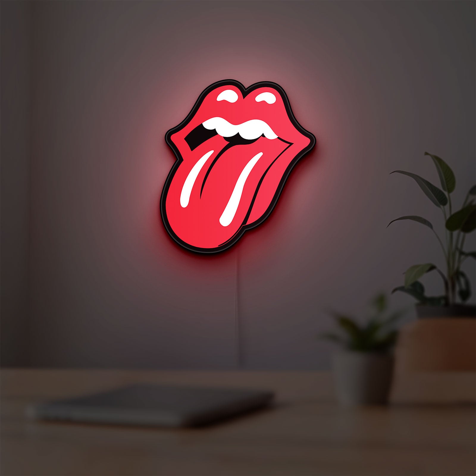 Rolling Stones LED lightbox hanging on a room wall with soft red light