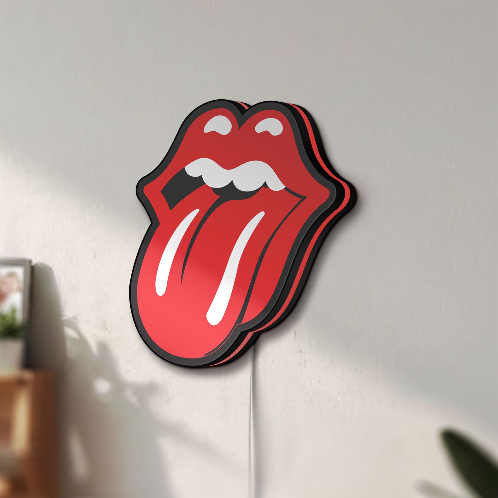 Unlit Rolling Stones LED lightbox mounted on a wall in daylight