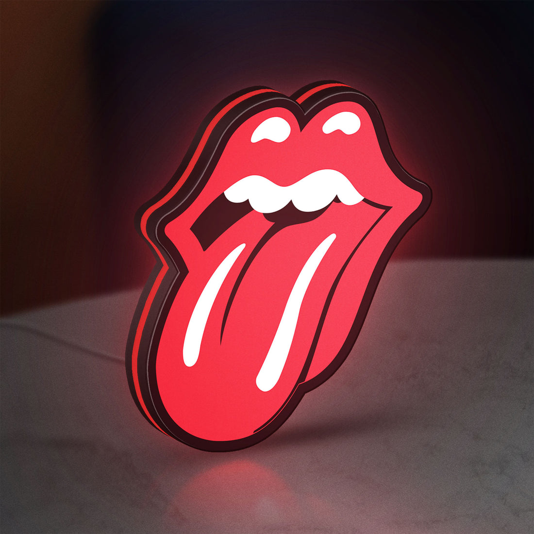 Rolling Stones LED lightbox hanging on a wall with red glow