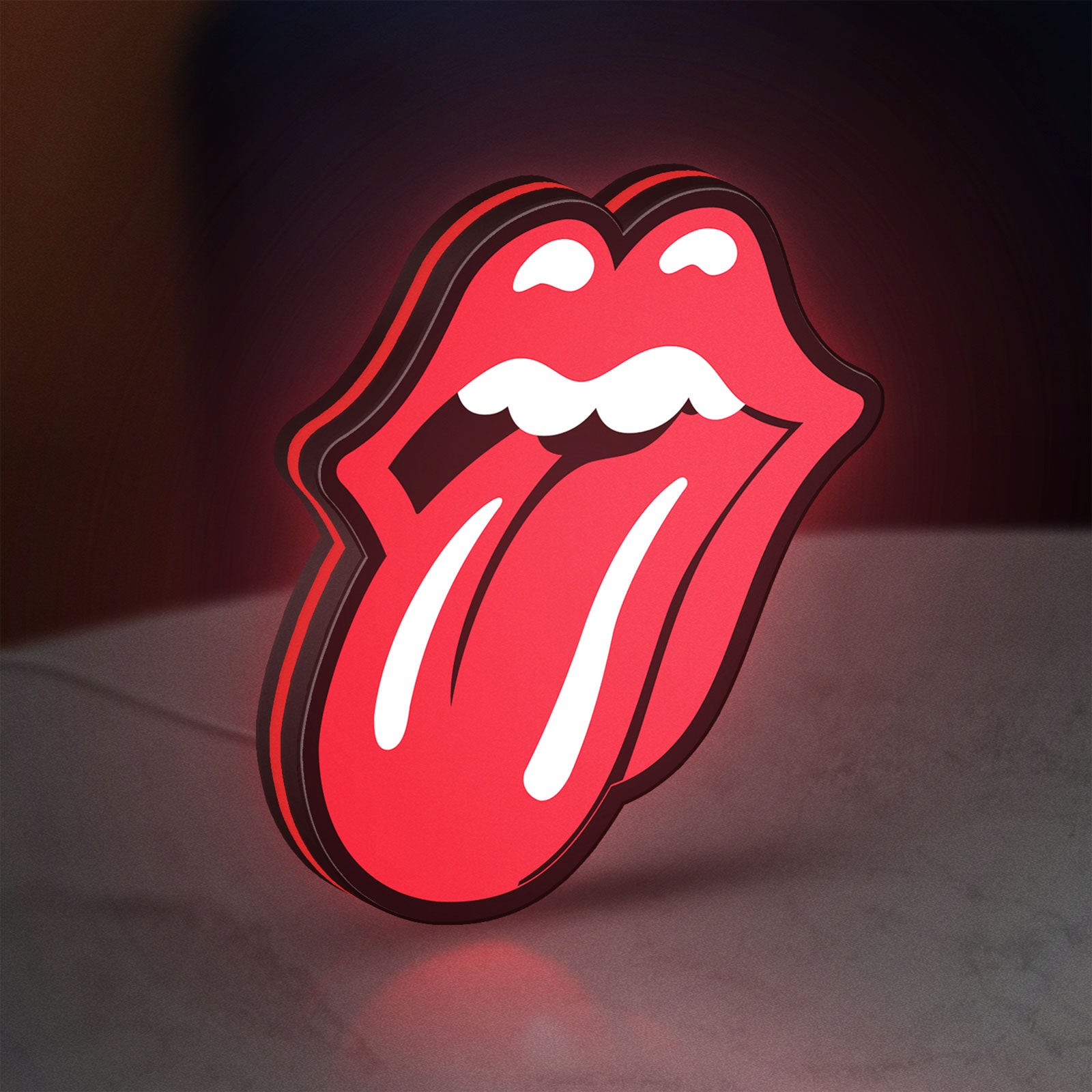 Rolling Stones LED lightbox standing on a desk from an angled side view with red glow