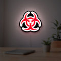 Biohazard LED lightbox hanging on a room wall with soft white light