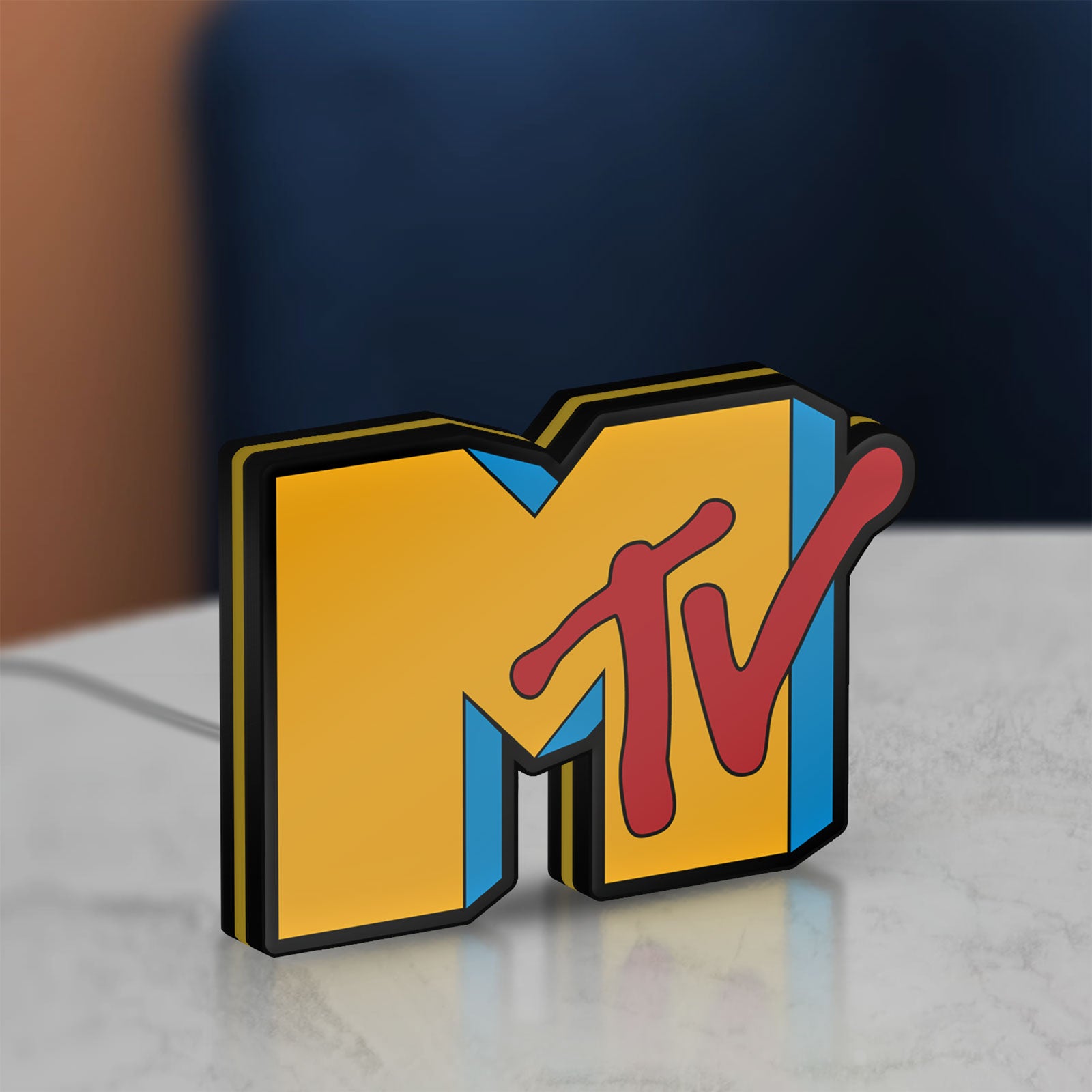 Unlit MTV Music Television LED lightbox standing on a desk from an angled side view