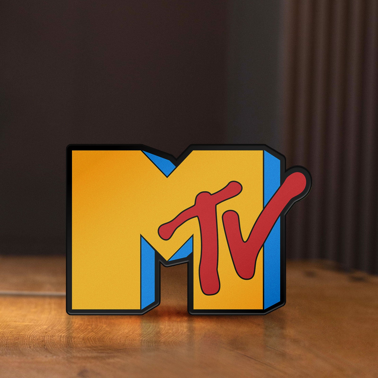 Front view of unlit MTV Music Television LED lightbox sign on a wooden desk