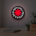 Red Hot Chili Peppers LED lightbox hanging on a room wall with soft white light