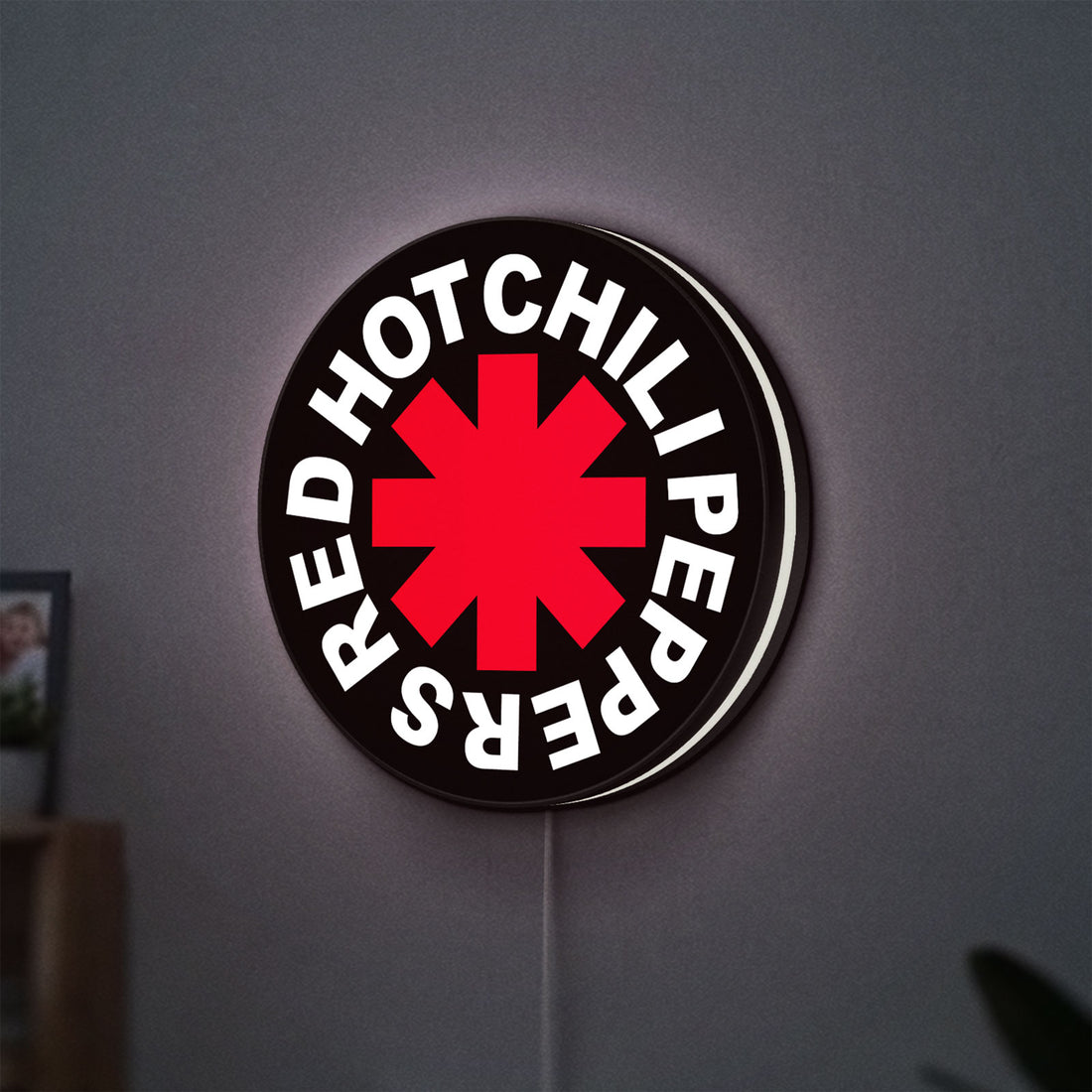 Red Hot Chili Peppers LED lightbox hanging on a wall with white glow