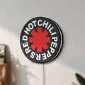 Unlit Red Hot Chili Peppers LED lightbox mounted on a wall in daylight