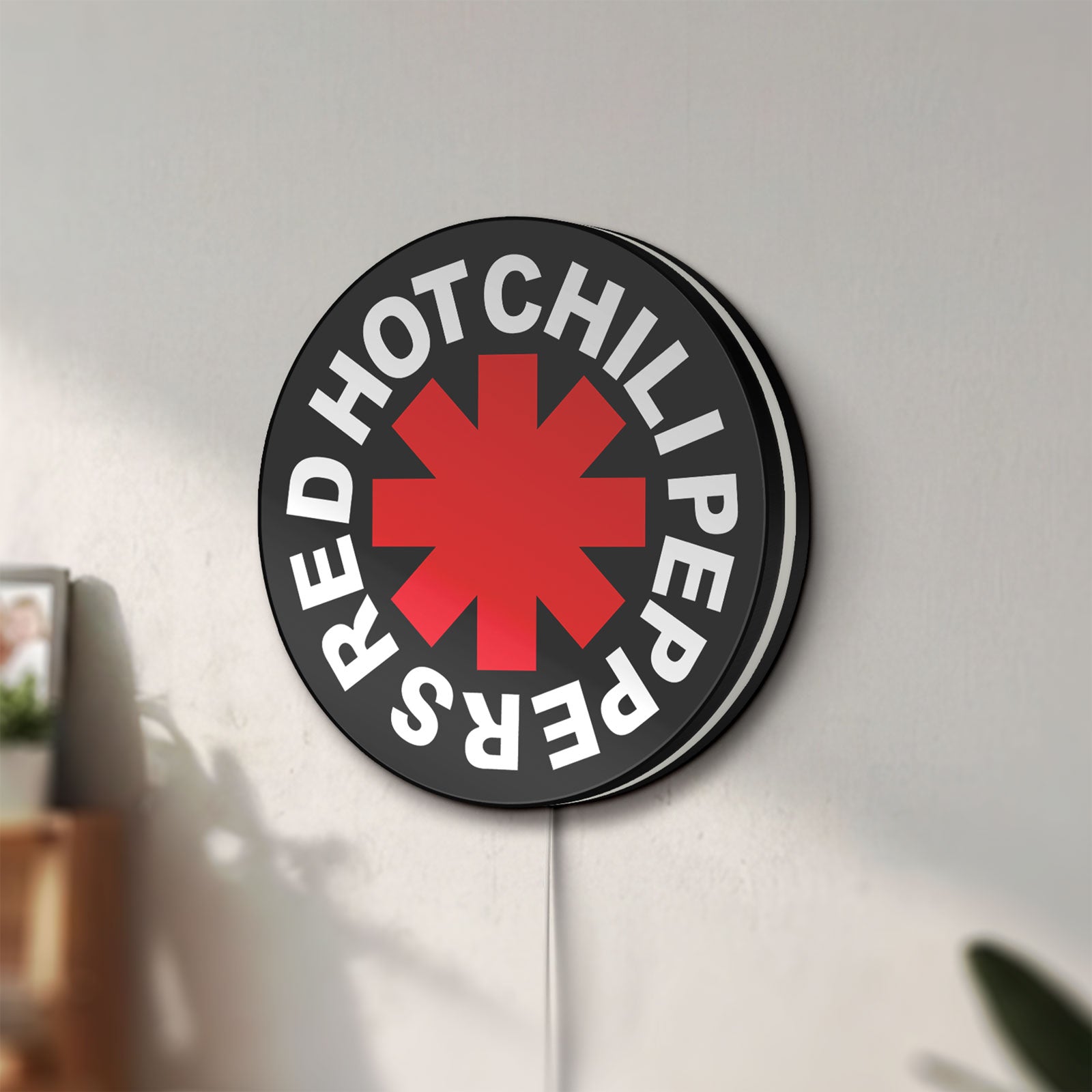 Unlit Red Hot Chili Peppers LED lightbox mounted on a wall in daylight