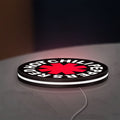Red Hot Chili Peppers LED lightbox lying flat on a desk with white glow