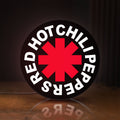 Front view of Red Hot Chili Peppers LED lightbox sign glowing on a wooden desk