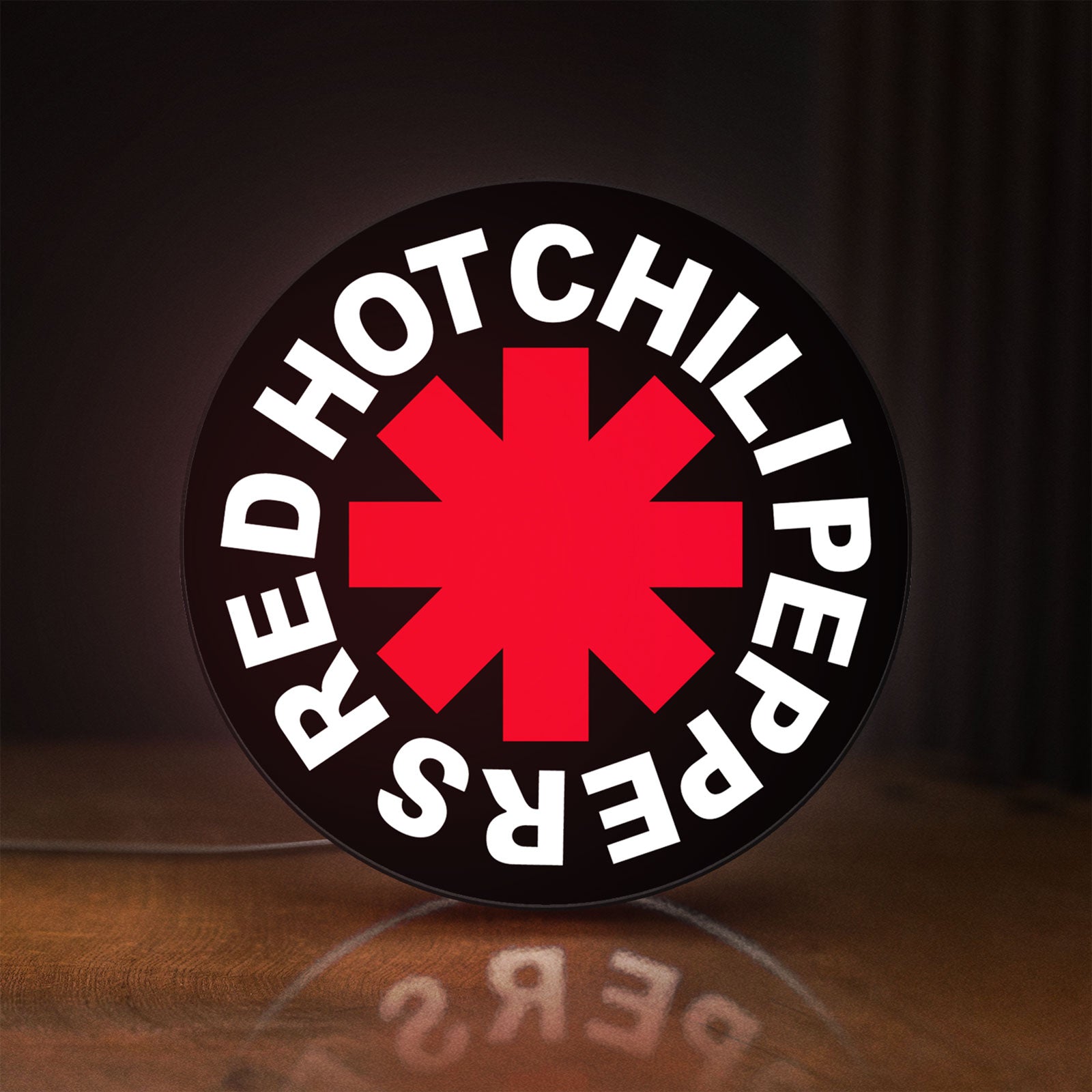 Front view of Red Hot Chili Peppers LED lightbox sign glowing on a wooden desk