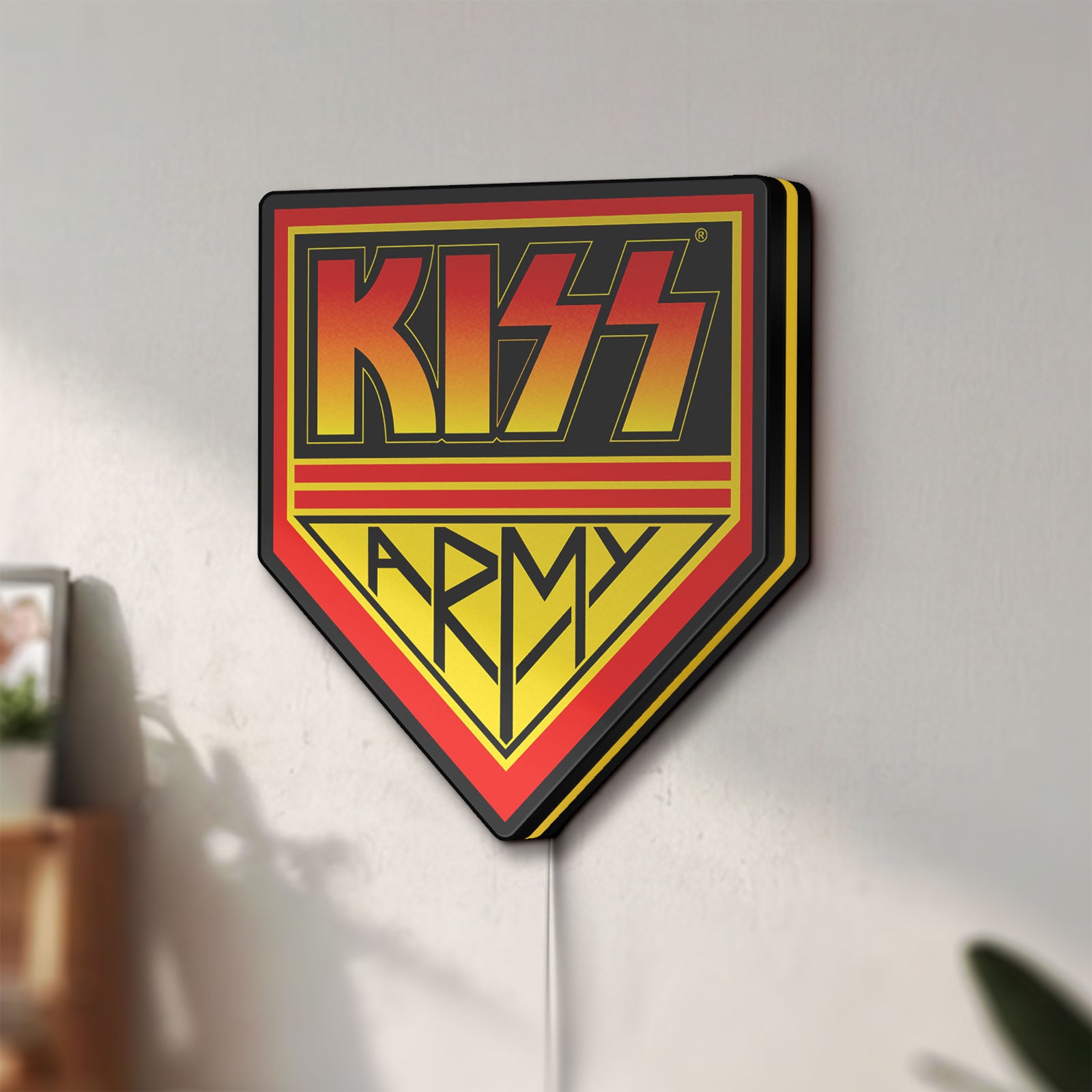 Unlit Kiss Army LED lightbox mounted on a wall in daylight